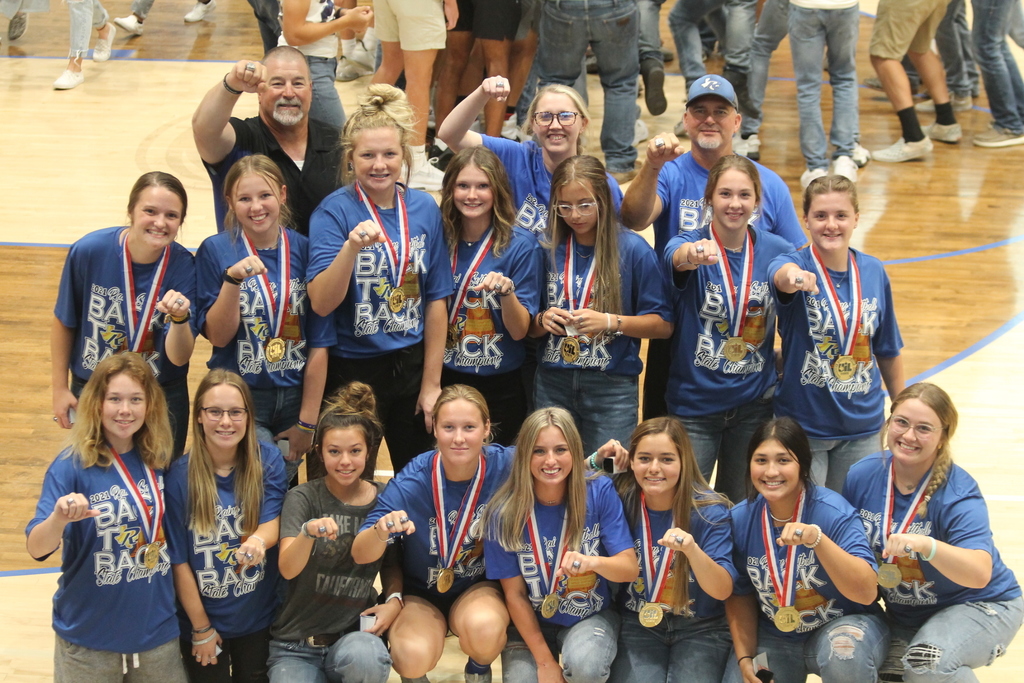 the remaining players of the Rains lady cat softball team and their coaches pose with their state medals and championship rings