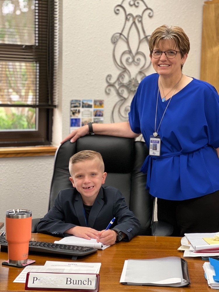 P. Bunch signing paperwork at Mrs Johnson’s desk for superintendent of the day duties