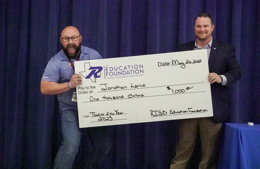 District Teacher of the Year receiving the giant $1,000 check from the Rains ISD Education Foundation